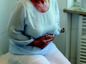 Woman holding her stomach because she is feeling sick